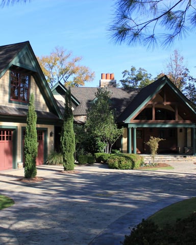 Waterfront property with boat dock, covered boathouse, and modern brick building with metal roof surrounded by mature trees